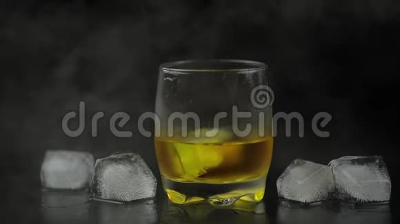 威士忌加冰在黑色背景上添加冰块一杯朗姆酒视频的预览图