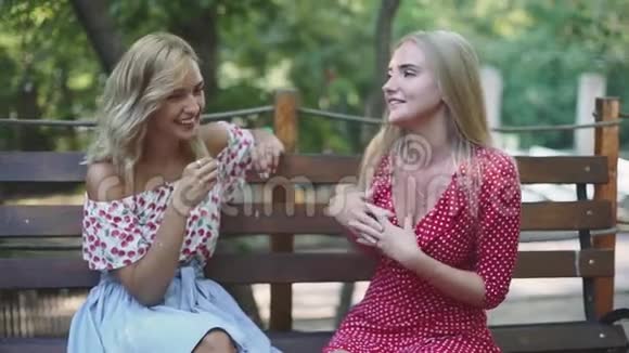 两个漂亮的金发女朋友在公园里聊天拥抱姐妹们在一起玩得很开心视频的预览图