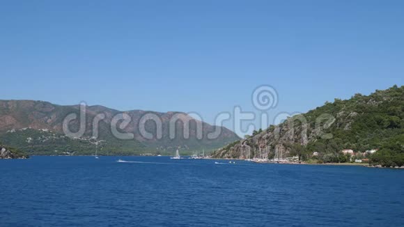 海洋景观美丽的海滨与游艇背景的青山在夏季视频的预览图