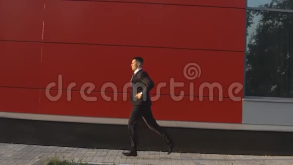 一个拿着包的商人正沿着街跑视频的预览图