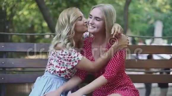 两个漂亮的金发女朋友在公园里聊天拥抱姐妹们在一起玩得很开心视频的预览图