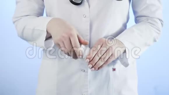医生用蓝色背景从瓶子里倒出药丸视频的预览图