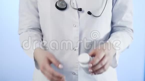 医生用蓝色背景从瓶子里倒出一片白色药丸视频的预览图