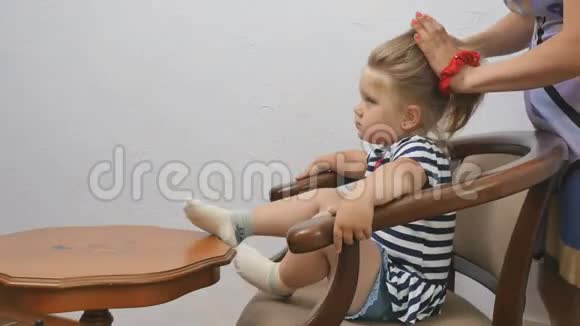妈妈给一个女儿梳头小女孩扎马尾辫视频的预览图