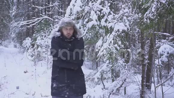 一个冬天森林结冰的年轻人他冻僵了搓了搓手弹起来视频的预览图