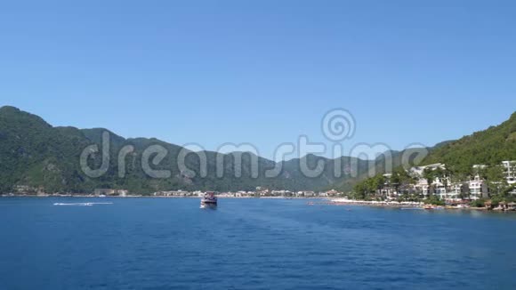 海滨度假胜地夏季乘游船在蓝清水上依山游泳视频的预览图