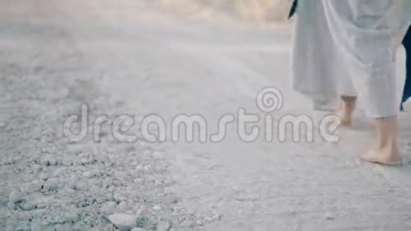穿着长裙的女人光着脚走在沙地路上身体的一部分视频的预览图