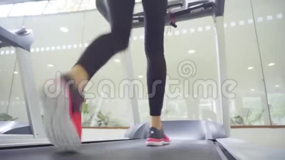适合运动的白种人女孩正在运动健身房的跑步机上行走视频的预览图