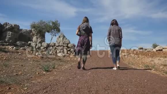 在碎石路上向前走的年轻女子视频的预览图