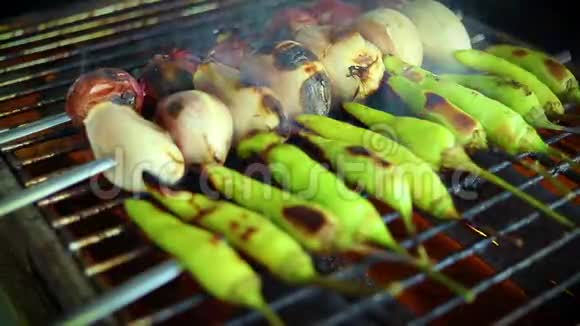 大蒜香葱和新鲜辣椒烤在炭火烤架上视频的预览图