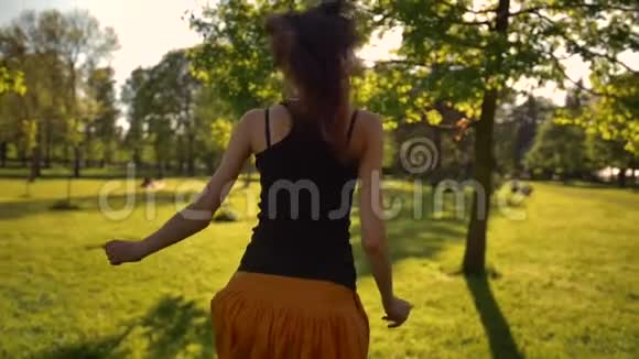 年轻迷人的女人在公园里快乐地奔跑视频的预览图