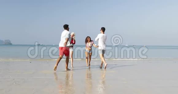 两对夫妇在沙滩上水上男子抱着女人手中快乐快乐的人拥抱在度假中交谈的游客视频的预览图