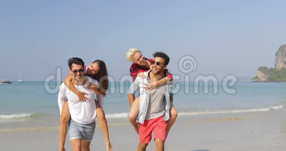 男人背着女人两对夫妻在海滩上奔跑快乐的人度假视频的预览图