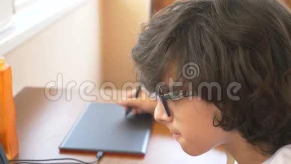 英俊的现代男孩在制作一个图形平板电脑他看着笔记本电脑的屏幕4k慢动作视频的预览图