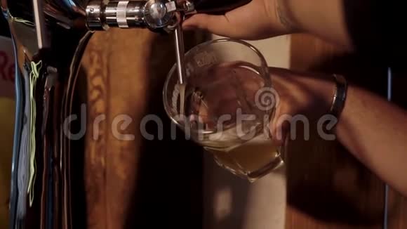 酒保把新鲜的冷啤酒倒在玻璃杯里视频的预览图