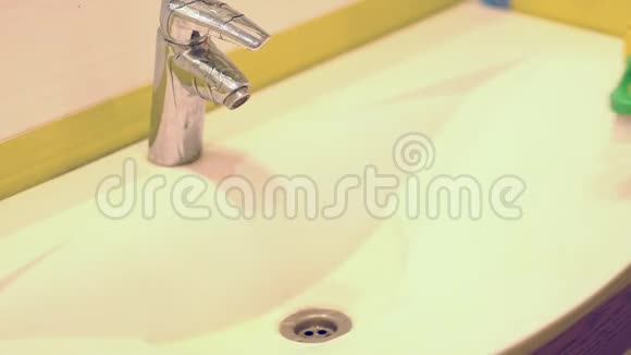 慢动作女人在家里的浴室里做家务用喷雾洗涤剂清洗水槽和水龙头封闭的视野视频的预览图