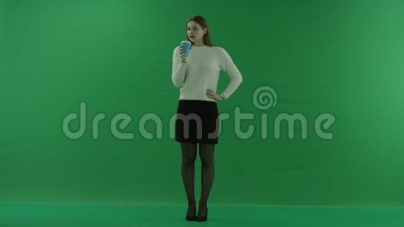 女孩从绿色屏幕上的玻璃上喝酒视频的预览图