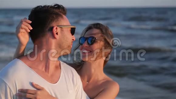 两个情人一起在海边度过时光在波浪背景下拥抱视频的预览图