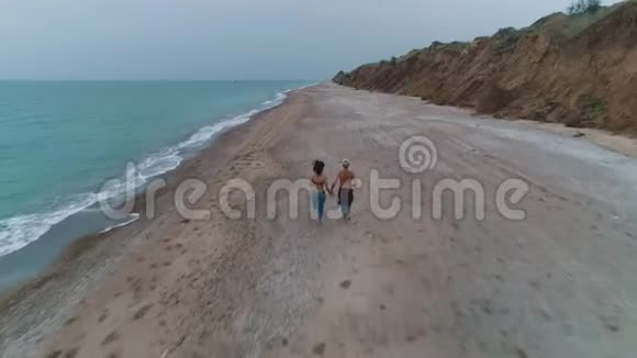 两对夫妇在海滩上奔跑的鸟瞰图视频的预览图