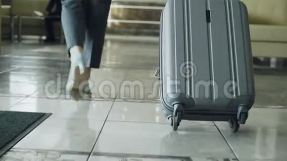 从酒店大厅走过的女商人多利的腿拉着行李停在接待处商务视频的预览图