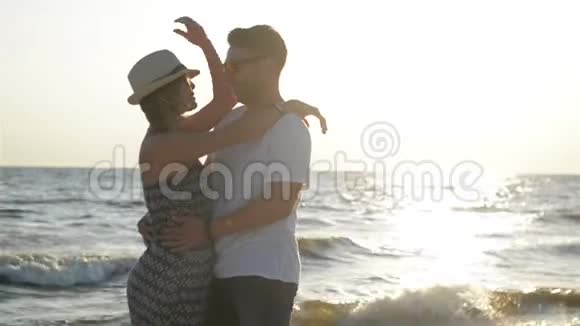 阳光明媚的夏日快乐的情侣在海边拥抱和交谈的肖像视频的预览图