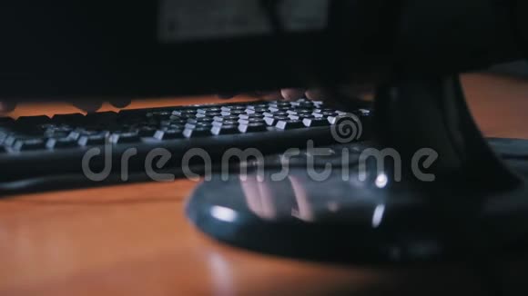 一个男人的手指在个人电脑附近的电脑键盘上打字视频的预览图