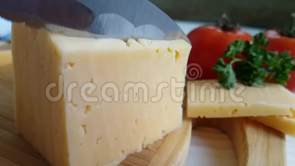 刀在木制慢镜头上切片奶酪视频的预览图