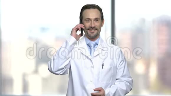 兴奋的穿着白色外套的男人在电话里交谈视频的预览图