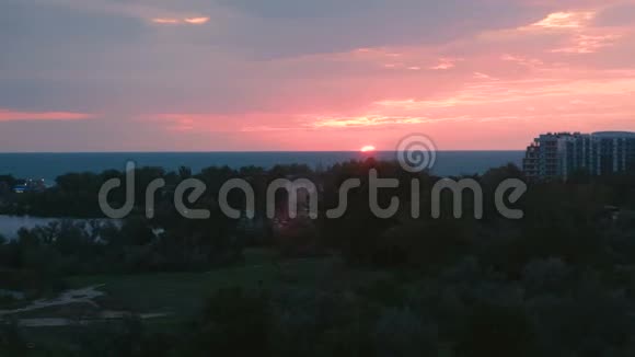 日落时分在沿海城镇的海面上晒太阳粉红色的日落在海上视频的预览图