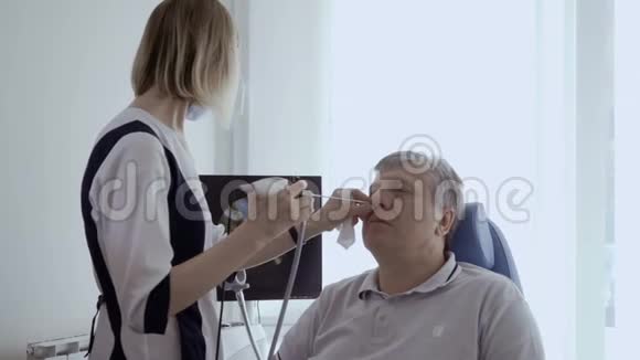医生用恩特望远镜检查老人的鼻子视频的预览图