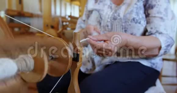 高级妇女从织布机上拔线和制纱视频的预览图