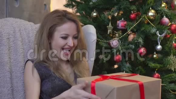 带礼物和圣诞树的装饰客厅里年轻微笑的女人的画像视频的预览图
