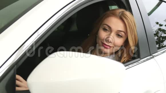 穿着红头发的女人盯着坐在车里的镜子视频的预览图
