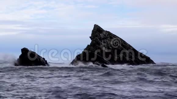 在一个秋天的暴风雨午后汹涌的海浪拍打着苏格兰的海岩堆视频的预览图