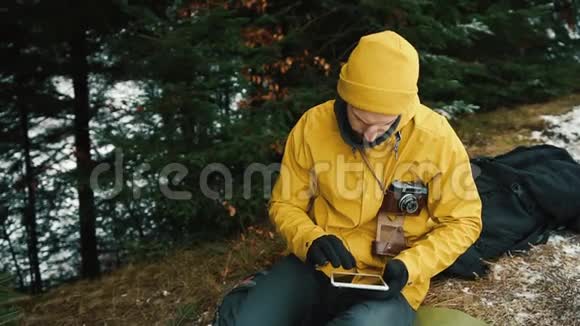 坐在青山旁边的绿树下一个年轻人正在寻找一条新路他拿着一块药片一块视频的预览图