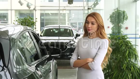 女顾客看着这辆新车在经销商处深思熟虑地选择了汽车视频的预览图