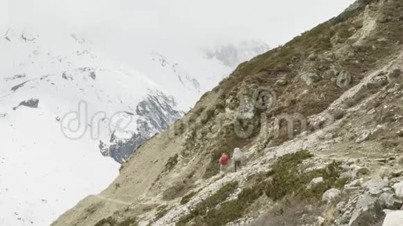 两个背包客在尼泊尔徒步旅行拉克山口马纳斯鲁地区视频的预览图