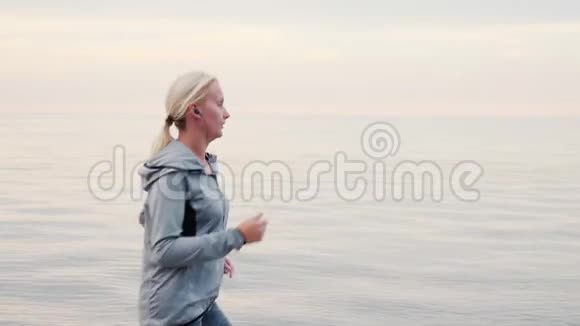 秋天慢跑清晨一个女人在平静的海面上奔跑视频的预览图