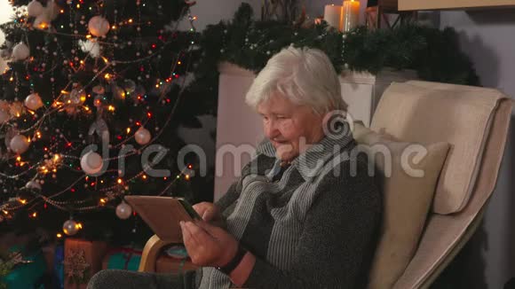 一位老年妇女在平板电脑上读留言视频的预览图