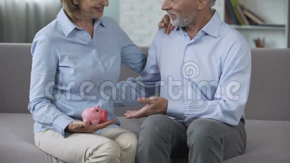 退休夫妇在沙发上拿着储蓄罐成熟后交了保险有保障视频的预览图