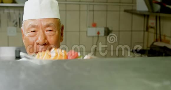 男厨在厨房里端一盘寿司视频的预览图