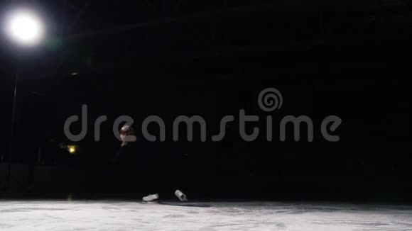 一个专业的花样滑冰运动员表演滑冰与旋转旋转顶部与她的轴在黑色背景视频的预览图