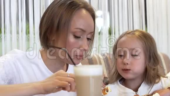 侧景一个可爱的年轻妈妈和一个可爱的小女儿一起吃饭视频的预览图