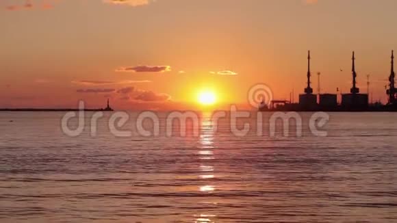 海港五彩缤纷的日落背景中的太阳落在地平线上视频的预览图