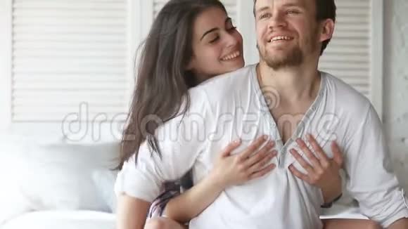 年轻夫妇坐在床上美女拥抱男人视频的预览图
