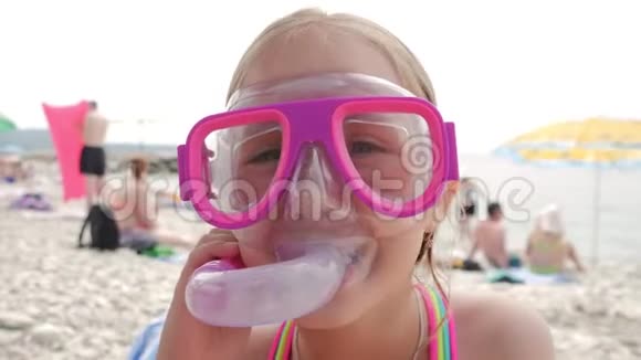 美丽的小女孩在海上玩耍可爱的微笑着戴着口罩和呼吸器管游泳4K视频的预览图