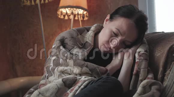 沮丧悲伤的女人双手抱着头坐在家里的扶手椅上充满魅力和悲伤的生活方式戏剧性的肖像视频的预览图