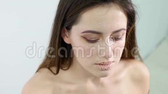 美容师女模特儿正在用刷子申请咨询把它放在模特眼化妆女人模特儿下面视频的预览图