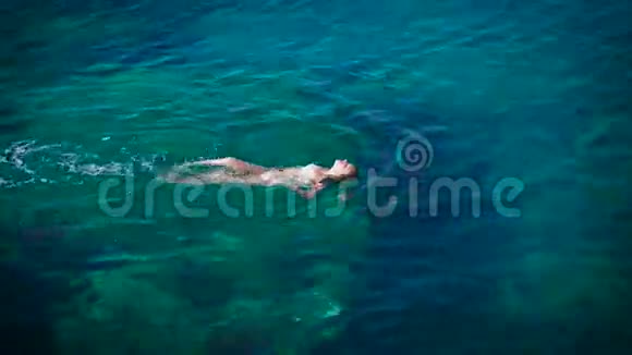 年轻女子在美丽的蔚蓝海中游泳视频的预览图