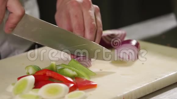 他把厨师的手伸近把一个红洋葱切成碎片视频的预览图
